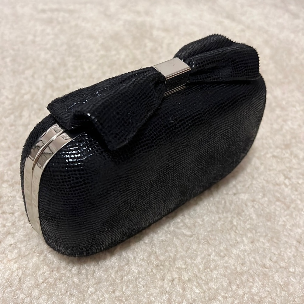 Black clutch with bow design! Chain inside to be used as cross body or clutch!